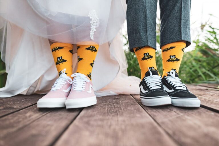 Braut und Bräutigam zeigen bunte Socken und Sneaker